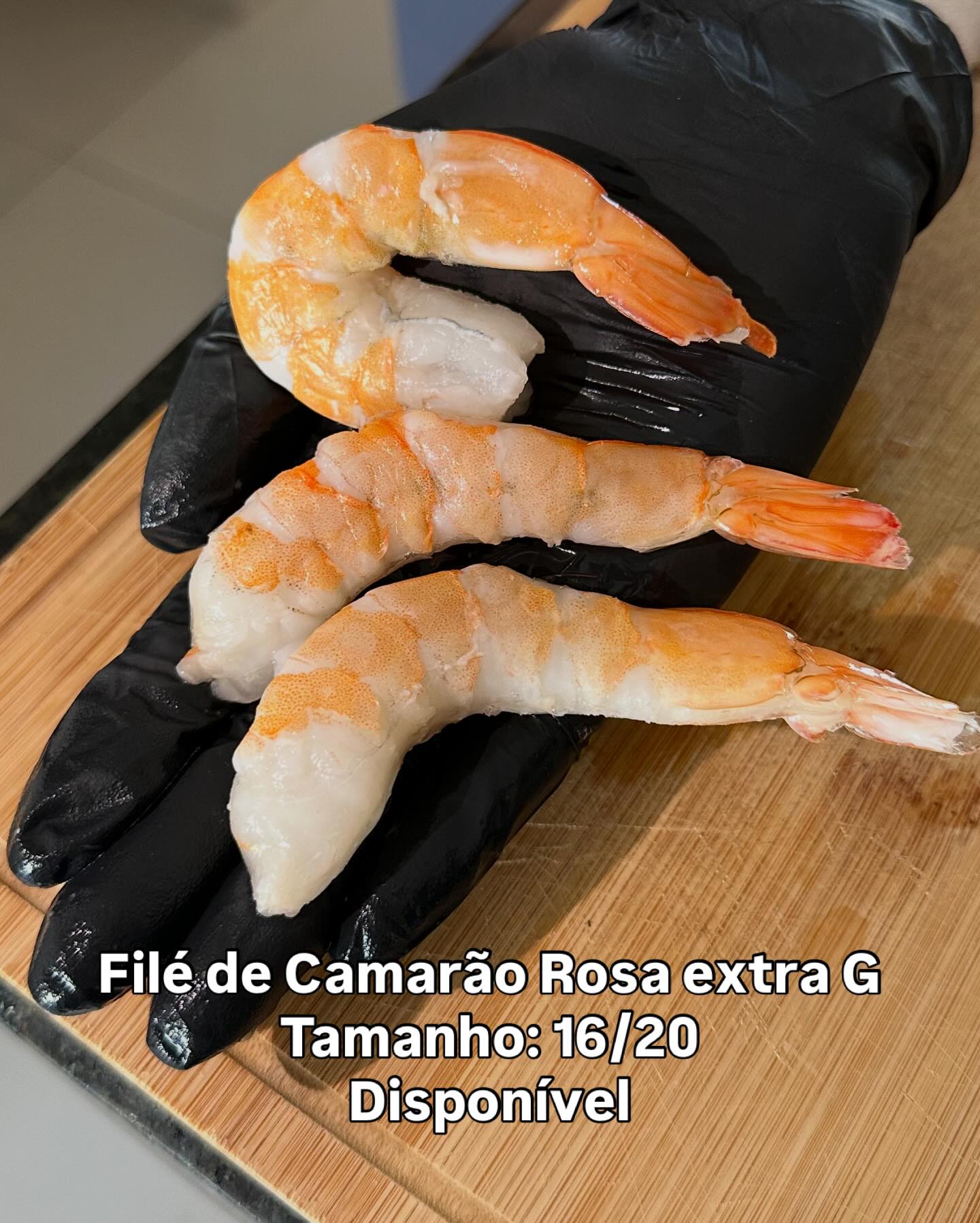 Filés de camarão grandes sobre uma luva preta